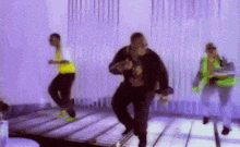 a group of men are dancing on a wooden floor in a room .