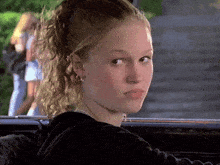 a woman with a ponytail is sitting in a car