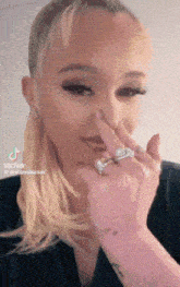 a woman with a ring on her finger is covering her nose