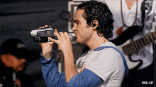a man singing into a microphone with a rbd.gif watermark on the bottom
