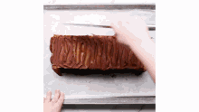 a person is spreading chocolate on a piece of cake on a pan .