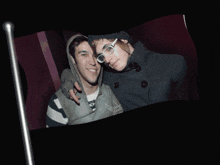 a couple of people standing next to each other with one wearing glasses