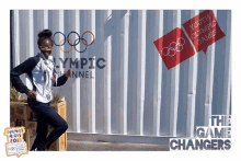 a woman stands in front of a wall that says youth olympic games