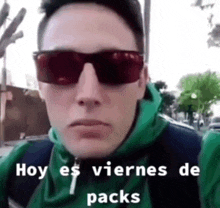 a man wearing sunglasses and a green hoodie says hoy es viernes de packs