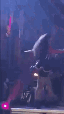 a woman is dancing on a stage with a kiss logo in the back