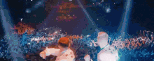 a couple of men are standing in front of a crowd of people at a concert .