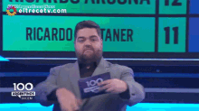 a man holding a 100 argentinas dicen card