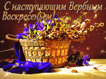 a wicker basket filled with purple flowers sits on a table with a greeting in russian