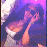 a woman wearing sunglasses and a white top is talking on a cell phone .
