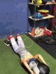 a person is laying on their stomach on a green mat