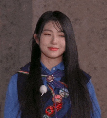 a woman wearing a blue shirt and a vest with a badge that says ' scouts ' on it