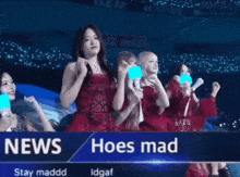 a group of women in red dresses are standing on a stage holding blue lights .