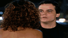 a man and a woman are looking at each other and the woman is naked