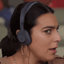 a close up of a woman wearing headphones and hoops