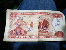 a 100,000 vietnamese currency note with a picture of a boat on it
