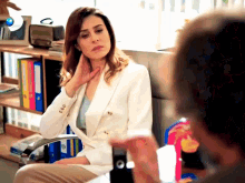 a woman sitting in a chair with a binder that has the letter o on it
