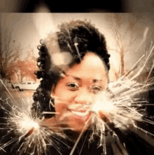 a woman is holding a pair of sparklers in front of her face .
