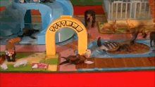 a toy zoo with animals and a yellow archway that says zoo