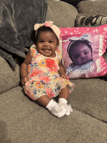 a baby is sitting next to a pillow that says serenity