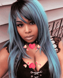 a woman with blue hair is wearing a black top with hearts around her neck