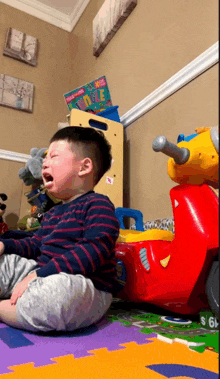a child is crying while sitting on the floor in front of a book that says ' jungle ' on it