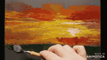 a person is painting a sunset with a spatula and the words made in animatica on the bottom
