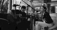 a man is playing a guitar while a woman sings into a microphone .