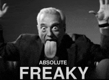 a man in a suit and tie is sticking his tongue out .