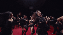 a woman in a black top is surrounded by many other women