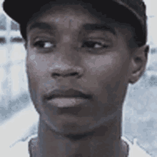 a man wearing a baseball cap is looking at the camera .