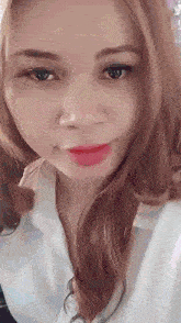 a close up of a woman 's face with a white shirt on .