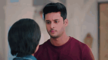 a man in a red shirt is looking at a woman in a blue shirt .