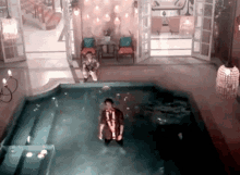 a man in a striped shirt is standing in a pool of water