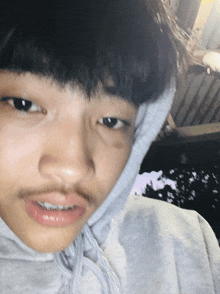 a young man with a beard wearing a hoodie