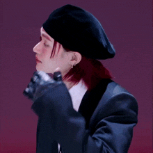 a woman with red hair wearing a black hat and a suit