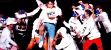 a man wearing a pizza shirt is surrounded by a group of people