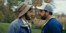 two men are looking at each other with one wearing a hat that says ' abercrombie & fitch ' on it