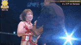 a woman in a wrestling outfit is being presented with a trophy by a man in a suit