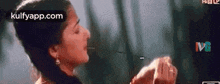 a woman is eating a piece of food with a spoon in her mouth in a movie .