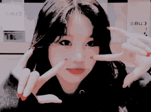a girl with red nails is making a peace sign with her hands