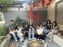 a group of young people are sitting in front of a building