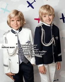 two young boys wearing military uniforms are standing next to each other in front of a sign that says novia mary