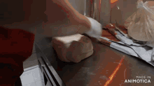 a person is kneading dough on a counter with the words made in animatica visible