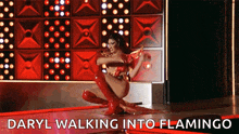 a drag queen is kneeling down on a stage with the words `` daryl walking into flamingo '' written above her .