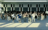 a group of people are dancing in a gym and one of them has the number 12 on their shirt