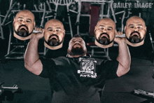 a man in a black shirt that says play to win lifting weights