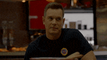 a man in a black shirt with a fire department logo on his chest