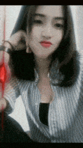 a woman wearing a striped shirt is making a face