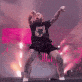 a man with tattoos on his legs and arms is dancing on a stage