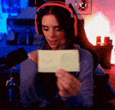a woman wearing headphones is holding a piece of paper that says ' i love you ' on it